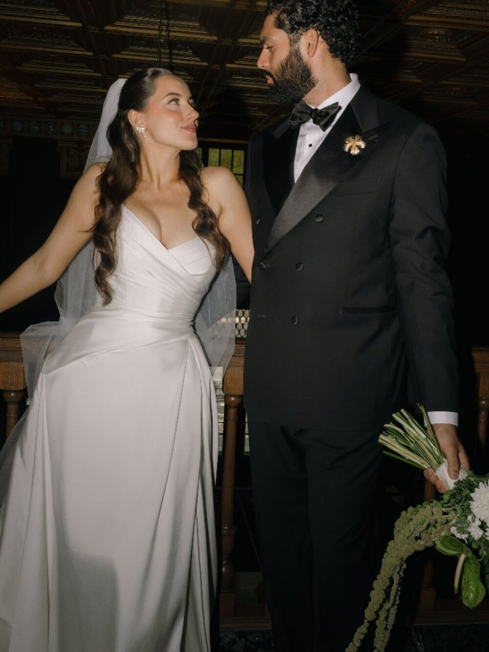 Strapless white wedding dress with asymmetrical waistline, high slit, and train